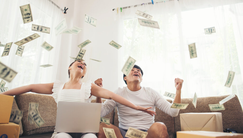 Happy couple smiling successful sitting under money rain. busine