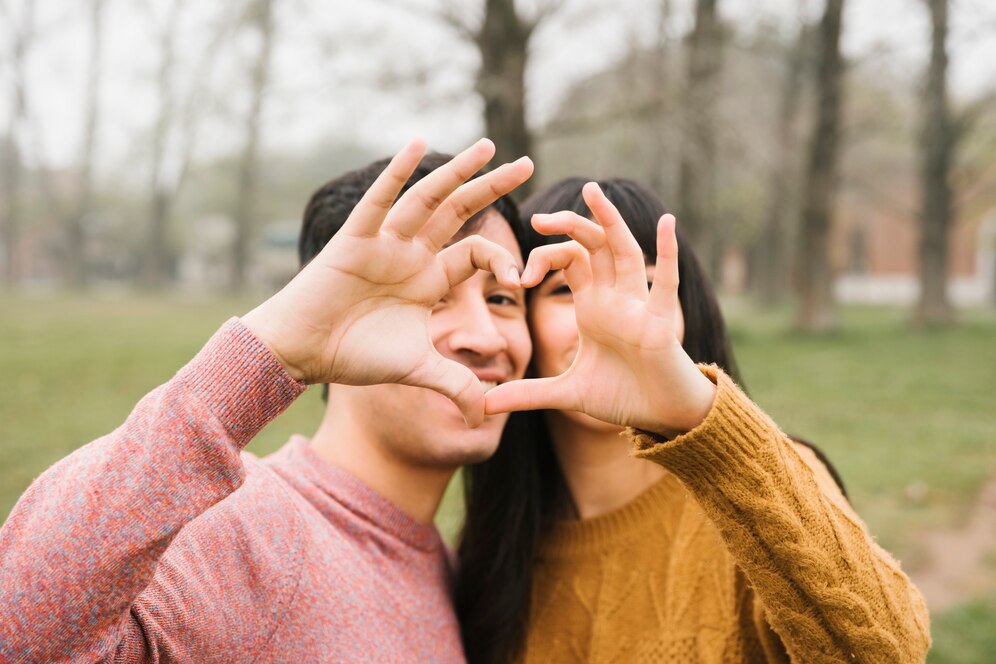 Happy young couple hugging showing heart sign 23 2148215615