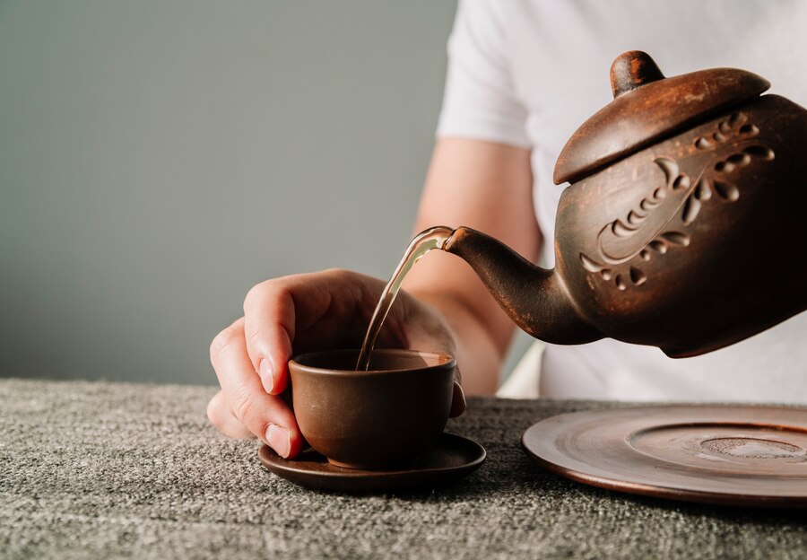 Person pouring warm tea cup 23 2148317007