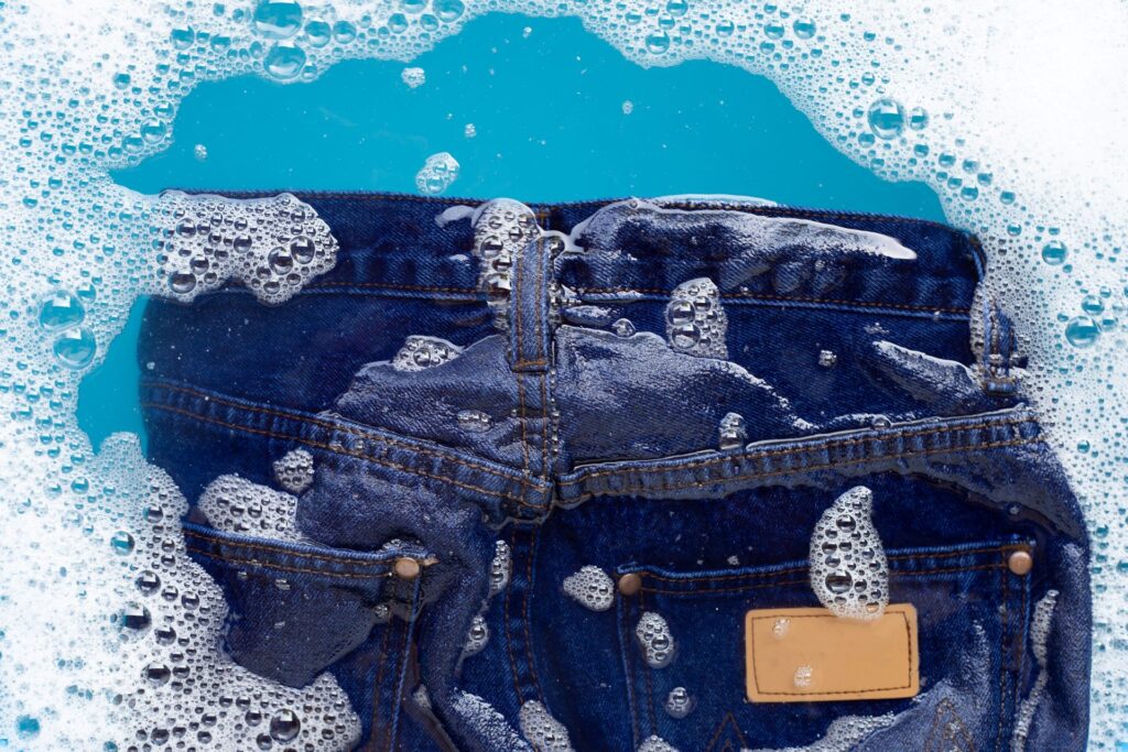 High angle view jeans with soap sud container